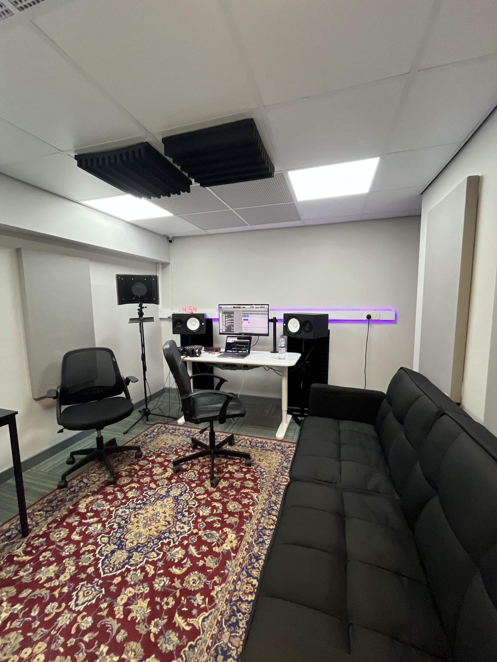 Warrington Music Studio control room with the sofa, monitors, and vocal shield
